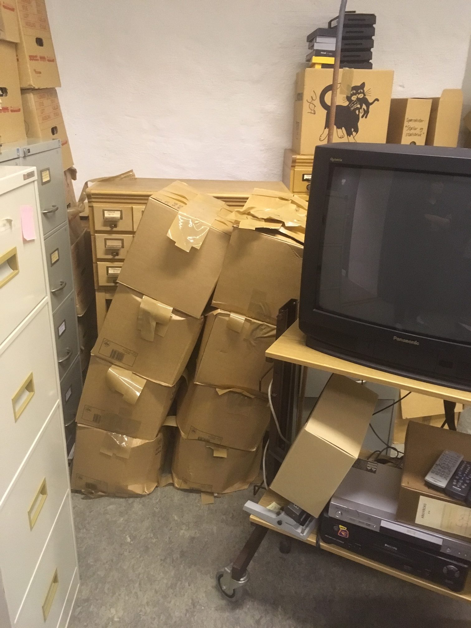 Arkivrom med esker og stativ med gammel TV